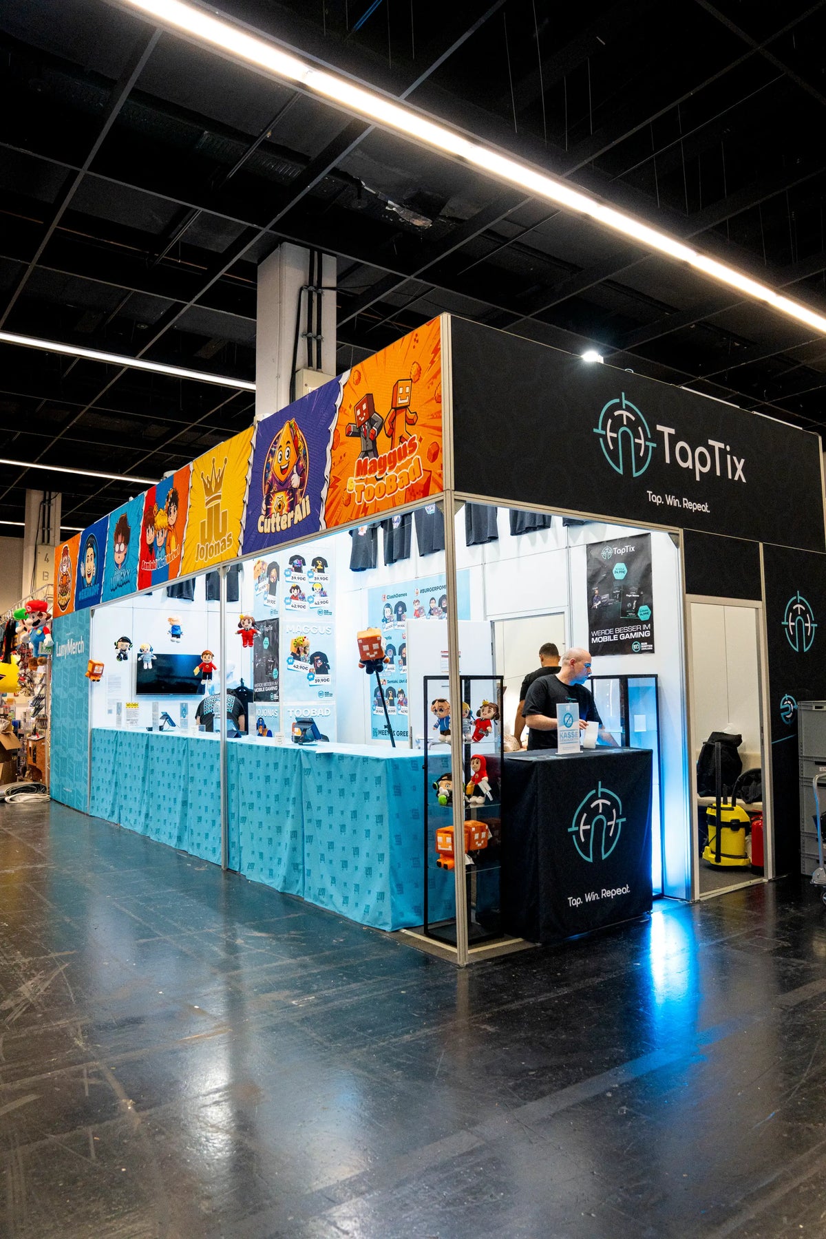 Der LunyMerch Messestand mit TapTix Bereich, Creator Bannern und Plushie Vitrine auf der gamescom 2026